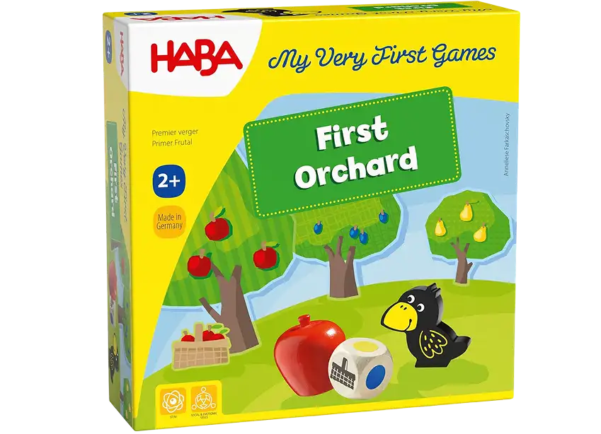 De doos van het bordspel voor kinderen „First Orchard“ van Haba, met een afbeelding van een kraai, een appel en een houten speelblokje